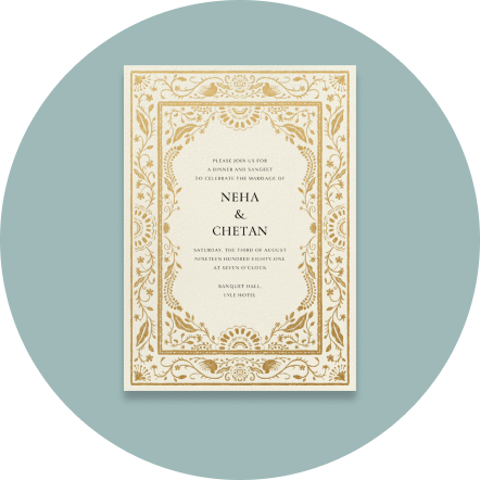 A boho-style wedding invitation with a gilded, intricate border.